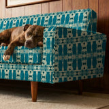 Symmetrical teal owl pattern with decorative floral elements on cream background