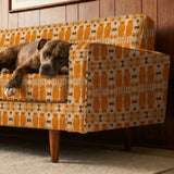 Symmetrical pattern of orange owls with brown details on beige background with decorative floral ele